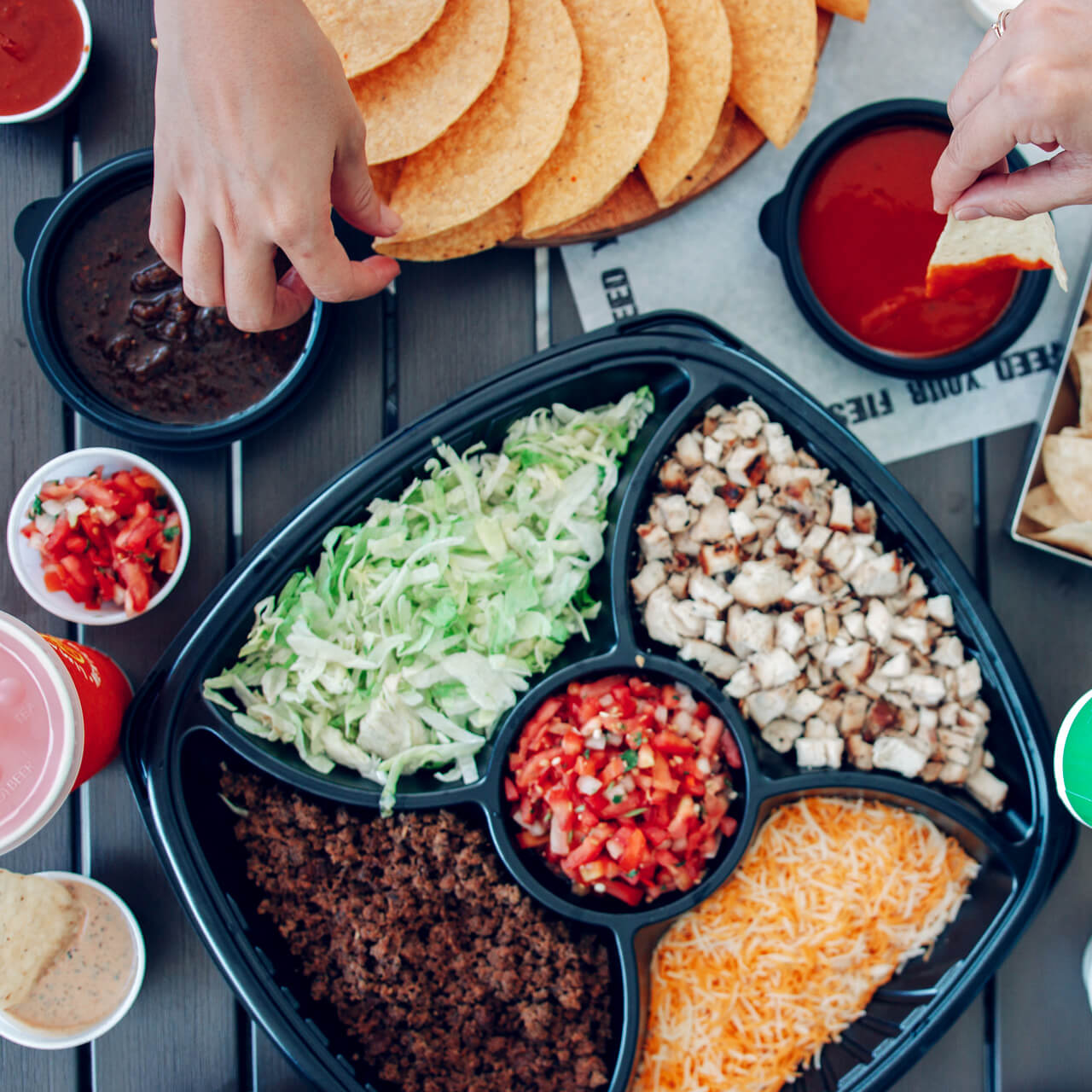 People dipping chips into salsa at a catered event