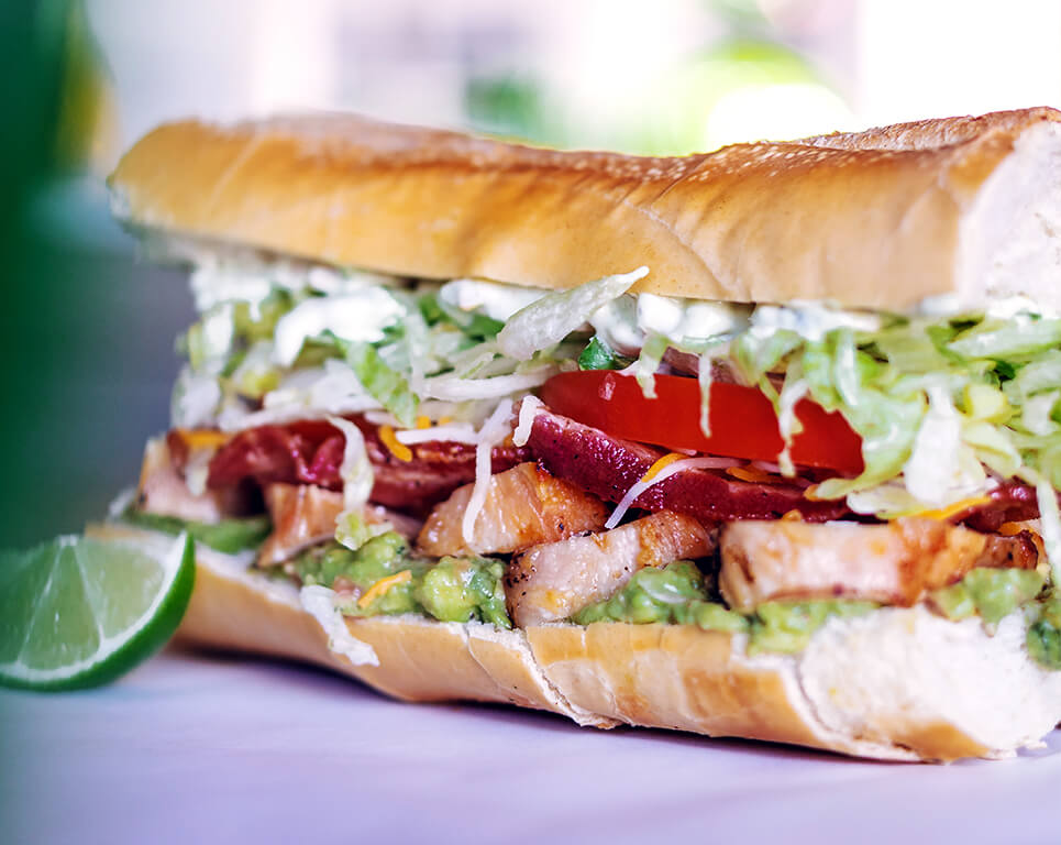 A Mexican-inspired take on a po boy sandwich includes spicy shrimp, cabbage, pineapple, cheese, beans and ranch dressing