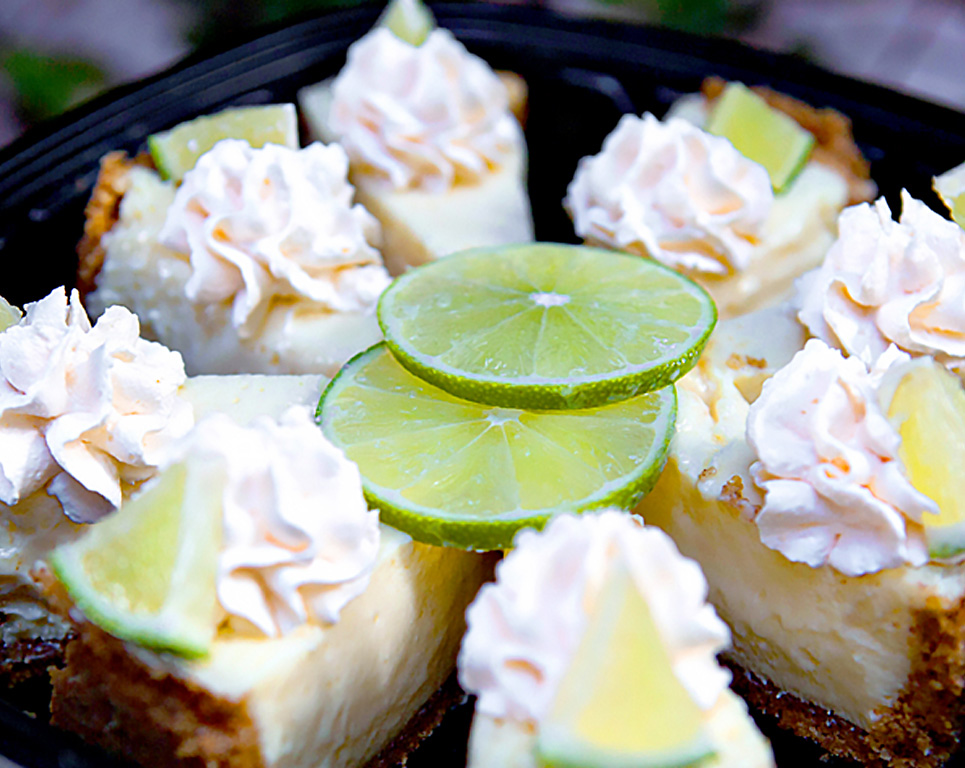 key lime pie topped with whipped cream and a lime slice