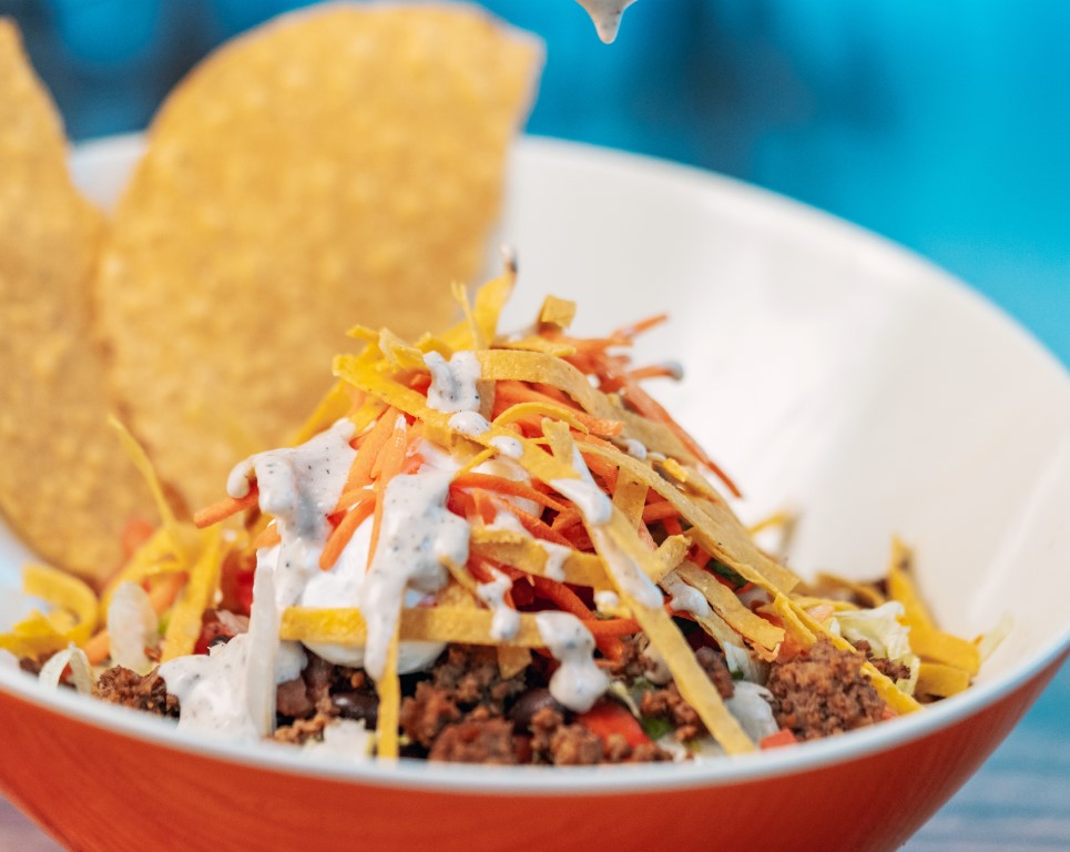 Taco salad in a bowl with tortilla strips and dressing